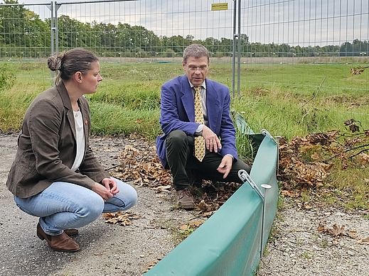 Agnes Becker und Stefan Müller-Kroehling vor den mit Bauzäunen abgesperrten Fangeinrichtungen